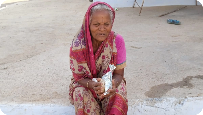 Elderly woman smiling while receiving food assistance from volunteers